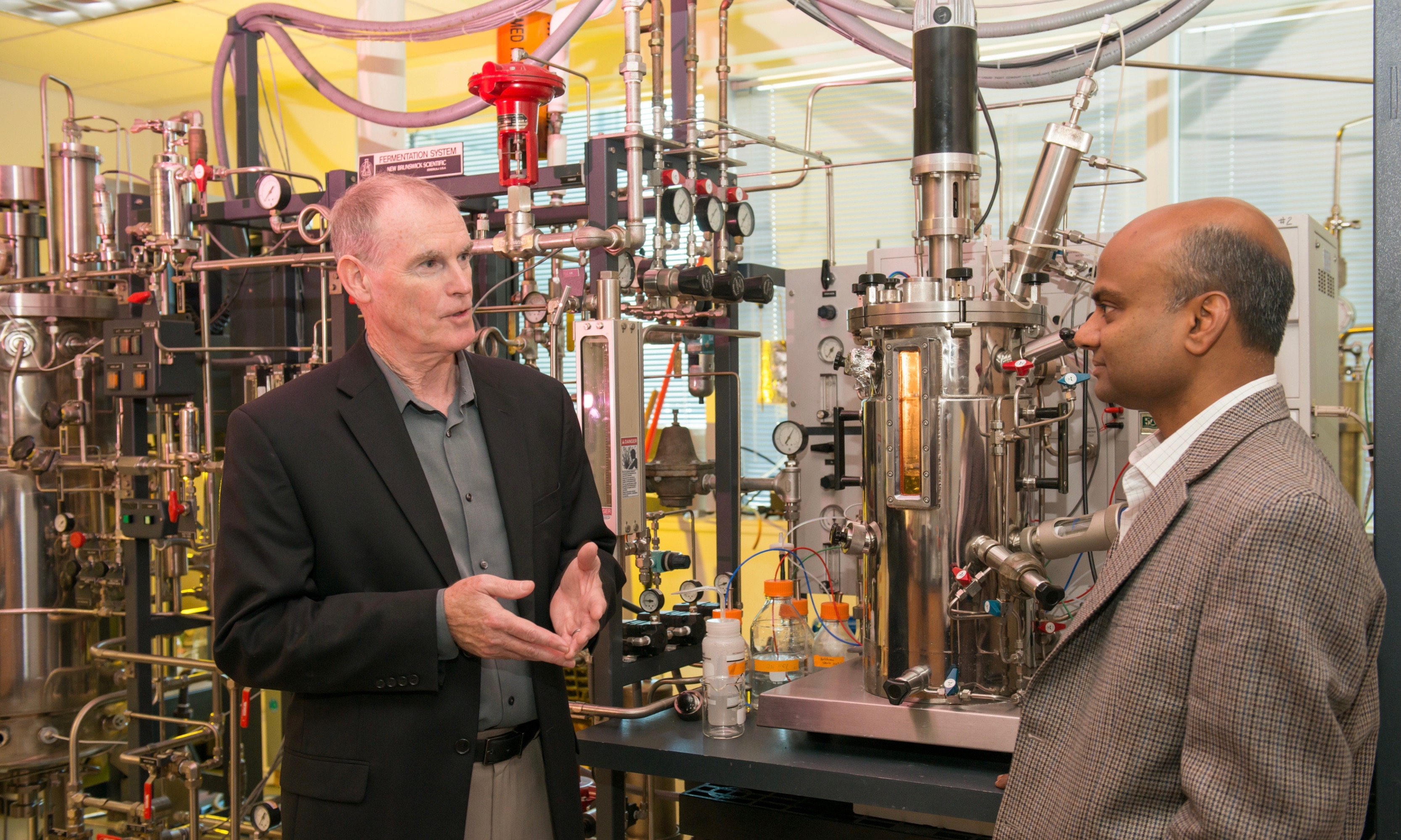 Two men in suits talking in a research facility